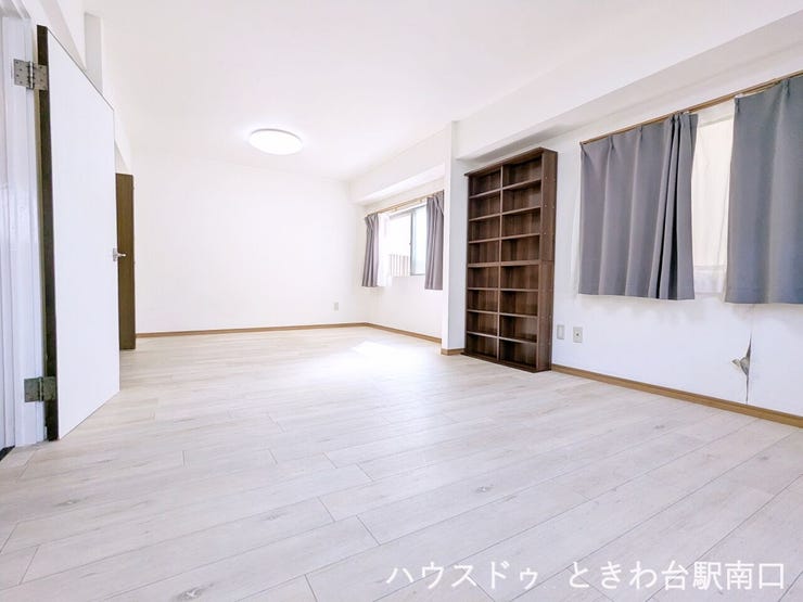 白を基調とした内装に明るい色のフローリングを合わせた、清潔感のある室内。約14帖の広々とした空間に加え、壁面には大容量のブックシェルフが備わっており、収納力も魅力です。