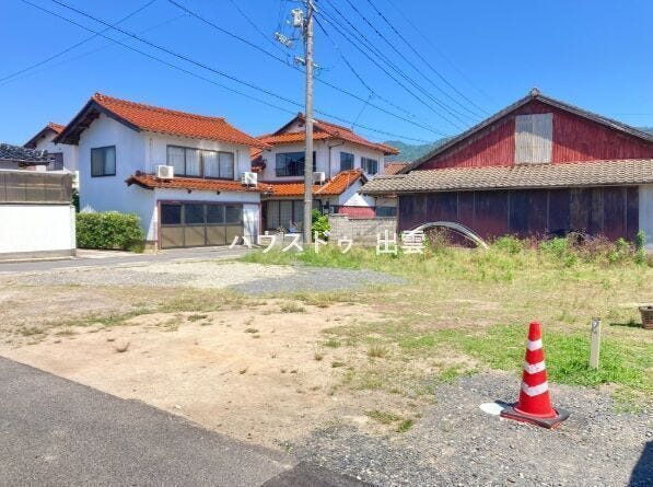 施工前現況写真です。周辺は住宅地の新規分譲地内の角地物件です。前面道路角からの外観写真です。