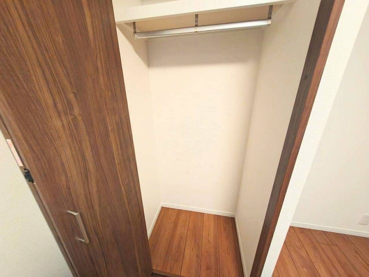 お部屋のフローリングと調和する木目調の扉を採用した収納スペースです。内部にはハンガーパイプを設置しており、衣類を整理して掛けられるため、居住空間をより広々と活用できます。