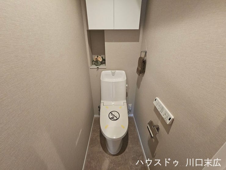 衛生的に使用できる温水洗浄便座を搭載。壁面には飾り棚として活用できるニッチスペースや、上部には扉付きの吊り戸棚を備えています。