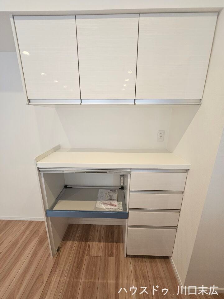 キッチン背面には収納力を誇るカップボードを設置。ダストボックススペースや家電用のスライドテーブルも備えた実用的な設計です。