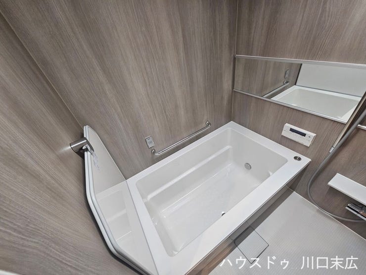 ゆったりとくつろげる形状の浴槽を採用したバスルーム。手すりを設けることで安全性にも配慮し、日々の疲れを癒やす空間です。
