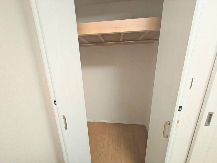 上部に木調の枕棚とハンガーパイプを装備したクローゼット。衣類を折らずにハンガー掛けできるほか、棚上には箱物や季節物の大きな荷物もまとめて収納可能です。