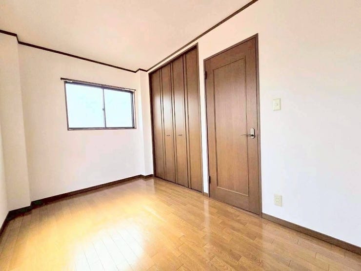 落ち着いた色合いの建具がアクセントになった洋室です。壁一面に大容量のクローゼットを備えており、衣類や大きな荷物もすっきり収納できます。お部屋の生活感を隠し、広々とした空間を維持しやすい造りです。