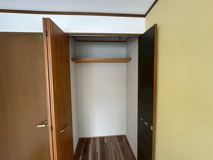 上部に枕棚を備えた折れ戸式のクローゼットです。丈の長い衣服を掛けられるほか、上の棚には収納ケースやバッグなどを整理して置けるため、空間を効率よく立体的に活用できます。