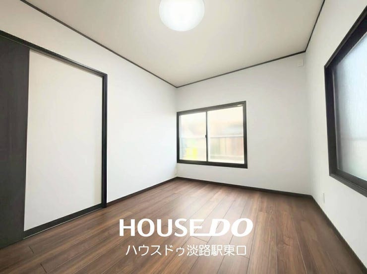 落ち着いたシックな床面と、黒フレームの建具・窓枠が引き締まった印象を与える室内です。白い壁紙とのコントラストが美しく、モダンでスタイリッシュな雰囲気を演出します。