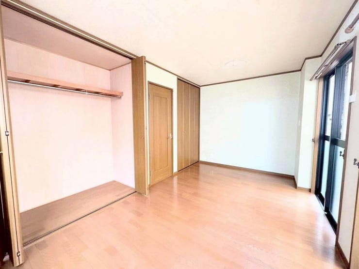 壁一面に大きなクローゼットを備えた開放感のある洋室。大きな掃き出し窓が配置され、明るく風通しの良い部屋構造です。