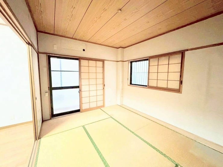 木の温もりが感じられる板張り天井と畳敷きが魅力的な和室。障子付きの窓が配され、日本の伝統美を感じさせる落ち着いた空間設計です。