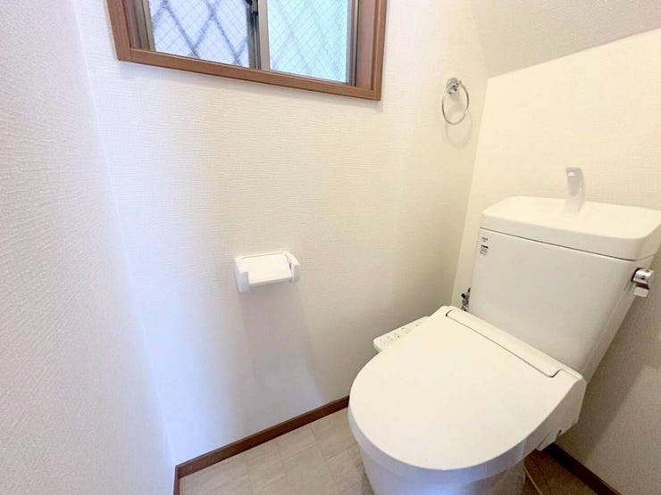 小窓から自然光が差し込む明るいトイレ空間です。手洗い付きタンクや温水洗浄便座を備え、使い勝手も良好。ホワイトをベースにした清潔感のある内装で、コンパクトながら心地よく使用できます。