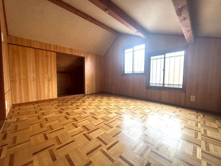 自然の風合いを活かした、木目が美しいフローリングと天井。窓から差し込む光が心地よく、落ち着いた空間を演出します。壁一面の収納は布団や季節物の衣類などもすっきりと片付き、快適に過ごせます。