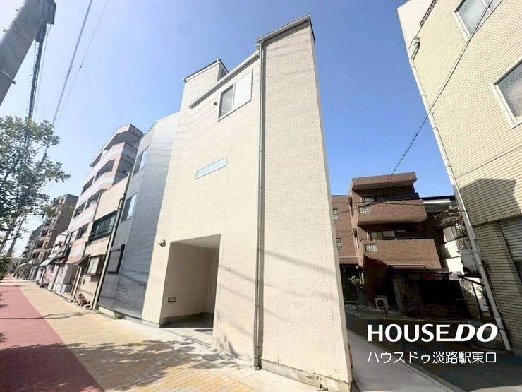 明るいベージュ系の外壁が都会的でスタイリッシュな印象を与える建物外観です。前面には整備された歩道が広がり、出入りもスムーズ。1階部分には駐車やアプローチに便利なスペースを備えています。