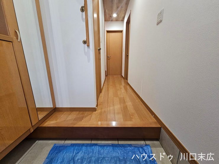 木の温もりが感じられるフローリングと手すりを備えたエントランスです。帰宅したご家族やゲストを優しく迎え入れる、丁寧な造りが魅力的な住まいの顔です。