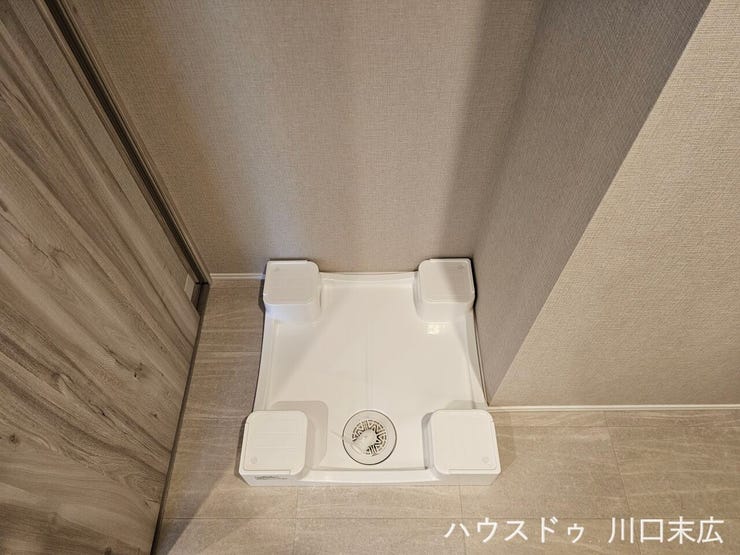 防水パンを備えた専用の洗濯機置き場。水漏れのリスクを軽減し、日々の洗濯作業をスムーズに行えるよう配慮された使い勝手の良い設備設計です。