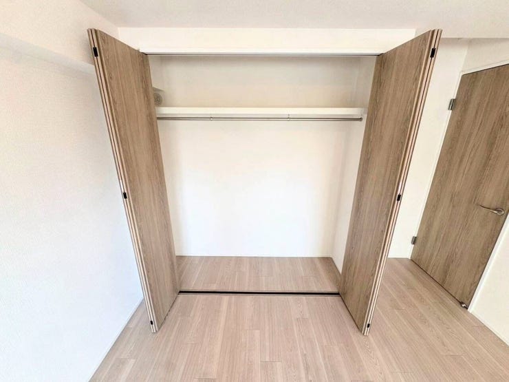 ハンガーパイプと上部棚を備えたシステムクローゼット。丈の長い衣類を折りたたまずに収納でき、上の棚にはバッグや季節物の小物整理に重宝します。開口部が広く出し入れもスムーズな設計です。