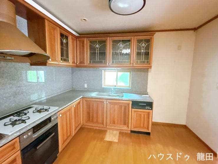 ナチュラルな木目調の扉と清潔感のあるホワイト天板の組み合わせが、キッチン全体を温かくおしゃれな空間に演出します。