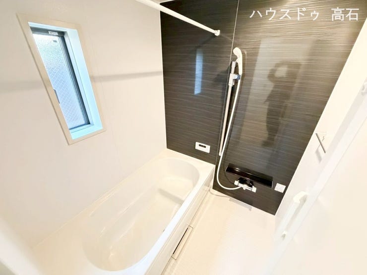 一日の疲れを癒す、シックで落ち着いたバスタイム。黒のアクセントパネルが高級感を演出する、洗練されたデザインの浴室です。