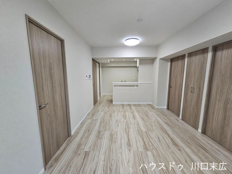 木目の美しさが引き立つフローリングとシックな建具が調和する、落ち着いた居室空間です。生活動線に配慮された開放感ある造りです。