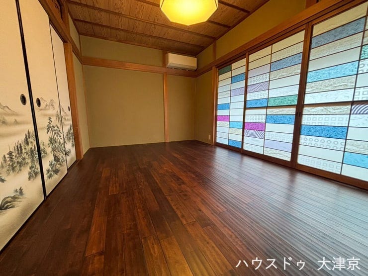 カラフルでモダンな障子紙が目を惹く1階洋室。木の温もりを感じるフローリングと和の意匠が美しく調和します。