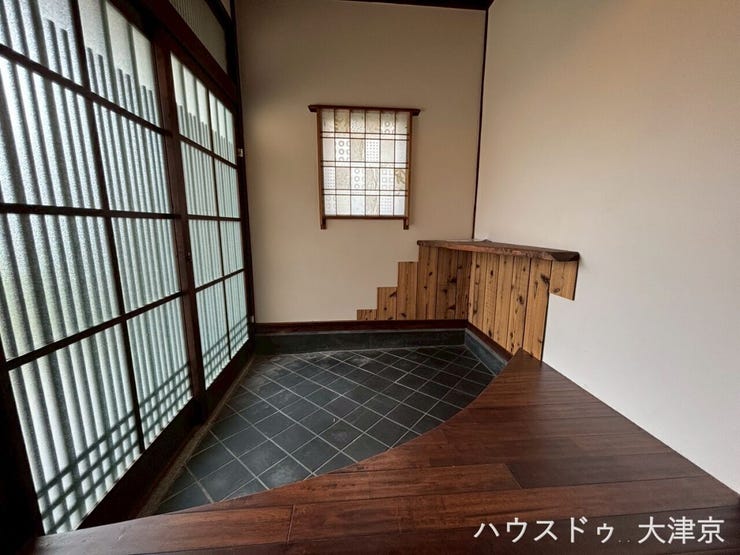 伝統的な格子の引き戸とモダンな框が融合。奥行きを感じる設計で、住まいの風格を伝える美しい玄関です。