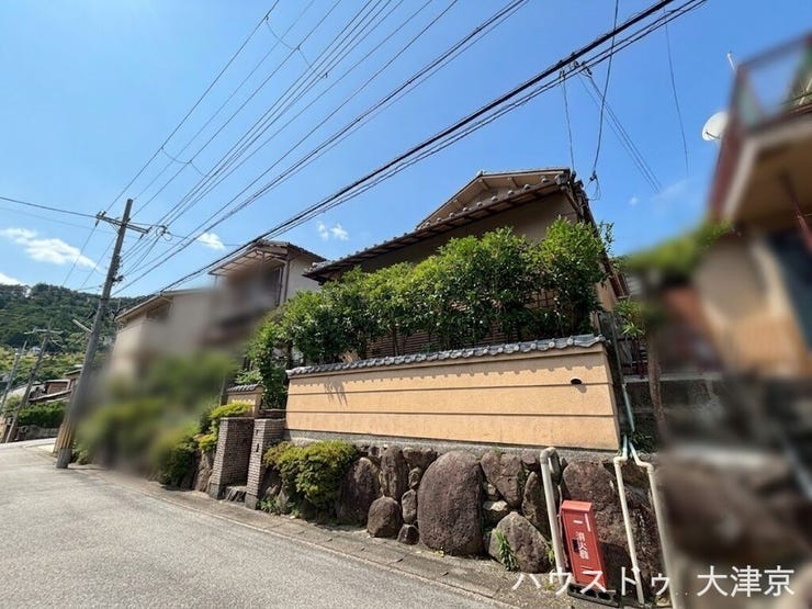 澄み渡る青空に映える美しい和の佇まい。立派な石垣と青々とした生垣が、邸宅の風格とプライバシーを守ります。