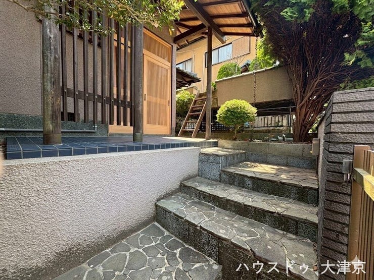 石畳と木の温もりが調和する、趣深い和の玄関アプローチ。※画像の一部を加工しております。