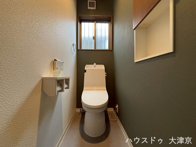 小窓から自然光が差し込む清潔感あふれる1階トイレ。トイレットペーパーなどを置ける棚やニッチも完備。
