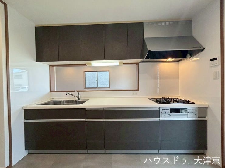 大容量の収納を完備した、シックな黒色のシステムキッチン。調理スペースも広く確保されています♪
