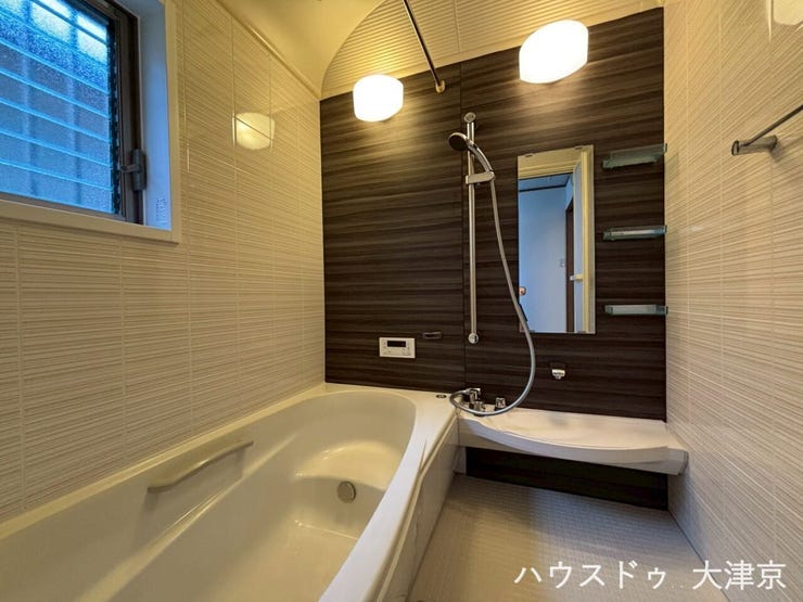 清潔感のある壁とシックなパネルのコントラスト。便利な収納棚や手すり付きで、家族みんなに優しい設計。