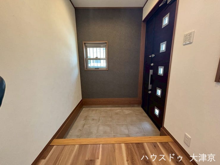 シックなアクセントクロスがおしゃれな玄関。小窓からの光が明るく、家族やゲストを優しく迎えます。