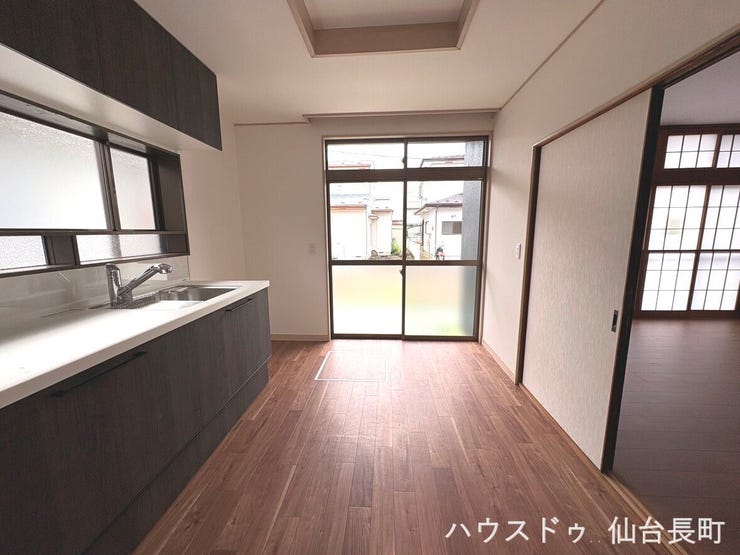 明るい陽の光が差し込むキッチン。吊戸棚付きのシステムキッチンで収納充実です。