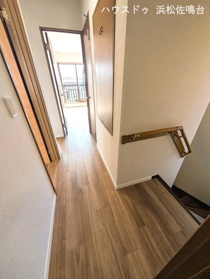 【リフォーム済み/2階廊下別角度】壁紙張替え、照明交換、床材としてフロアタイルの上張りを行いました。階段には窓がございますので、明るい日が差し込みます。