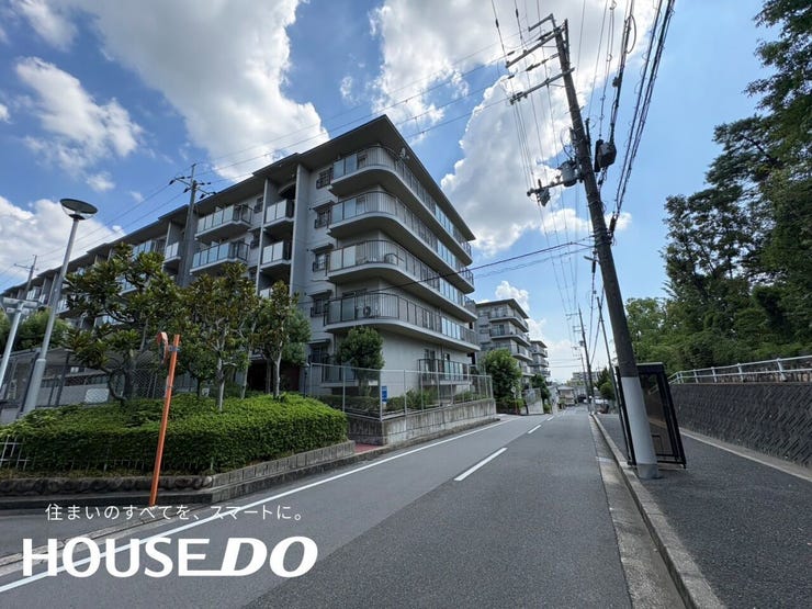 曲線を描く外壁とバルコニーが印象的な外観で、前面道路にはゆとりがあります。植栽も整い、通りからの見た目も好印象です。