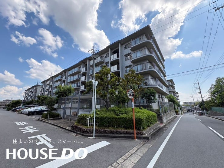 曲線を描く外壁とバルコニーが印象的な外観で、前面道路にはゆとりがあります。植栽も整い、通りからの見た目も好印象です。