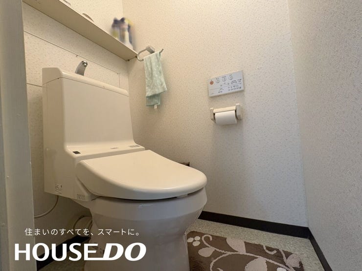 温水洗浄便座は壁面のリモコンパネルで温度調整ができ、棚にはタオル掛けも設置。清潔に使い続けられる設備です。