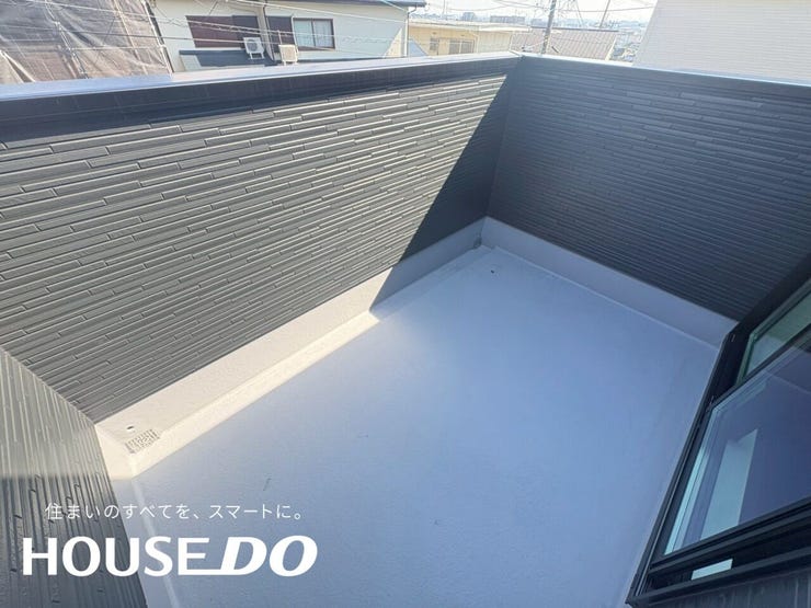 バルコニーの床と外壁のカット。黒いタイル調外壁とホワイトの床で見た目のコントラストが綺麗です。