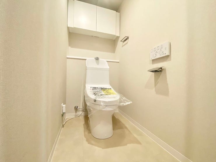 温水洗浄便座付きの清潔感あるトイレ。上部には吊戸棚があり、トイレットペーパーや掃除用品を見せずに収納できます♪