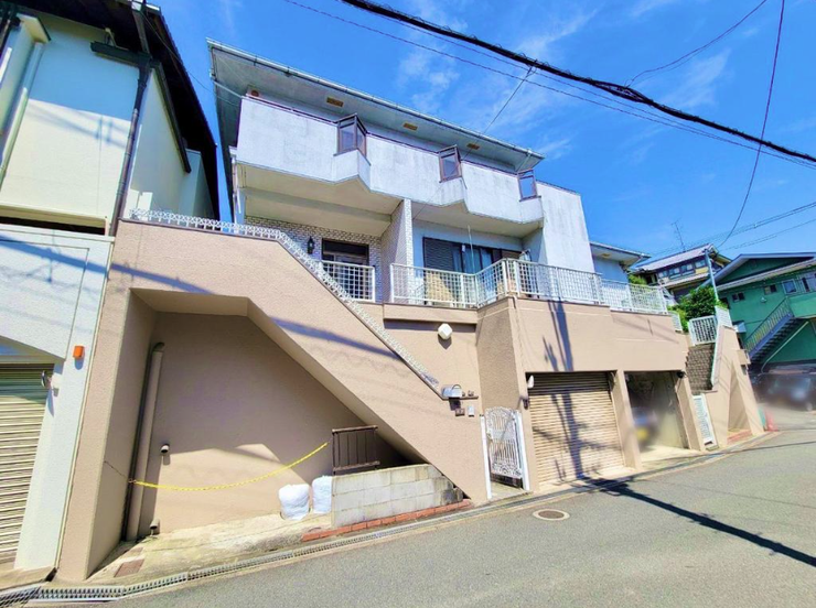 青空に映える明るい外観。バルコニー付きで、陽当たりや開放感を感じられる住まいです。