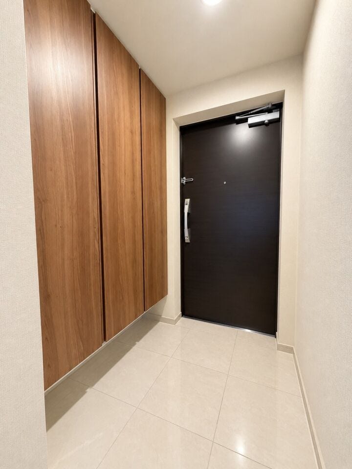 木目の収納と落ち着いた色合いの玄関ドアが調和した上品な玄関スペース。収納もしっかり確保されています♪※居住中の為、家具を消すなどの画像加工処理をしております。