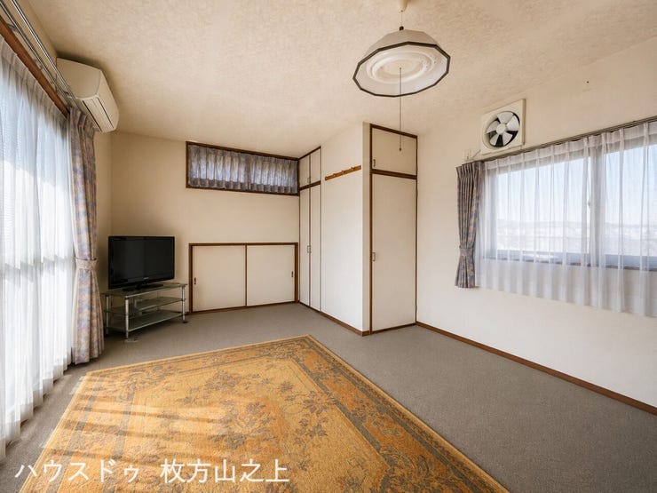 複数の窓を備えた明るい洋室。家具の配置もしやすい、すっきりとした空間です。