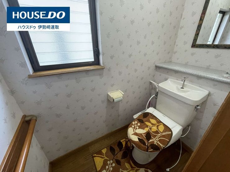 小窓から自然光が入り、明るく換気もしやすい清潔感のあるトイレです。手すりが設置されており、ご家族皆様が安心して使えるバリアフリー仕様。小物を置ける便利なカウンターや鏡も備わっています。