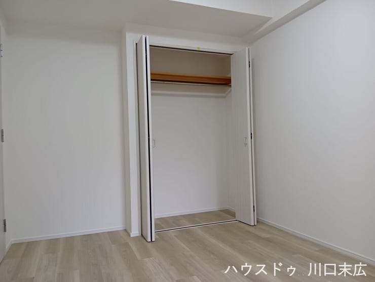 プレーンな内装で整えられた機能的な洋室。落ち着いた色合いの建具が空間を引き締め、多様な家具のレイアウトも楽しみやすい洗練されたお部屋です。