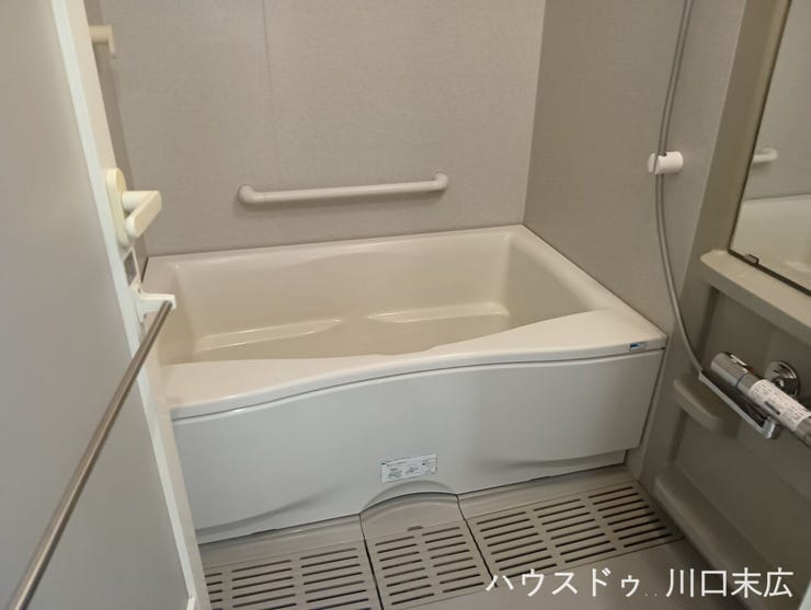 なめらかなフォルムの浴槽を備えた清潔感のあるユニットバス。一日の疲れを癒やすリラックスタイムを上質に演出し、心地よいバスタイムを提供します。