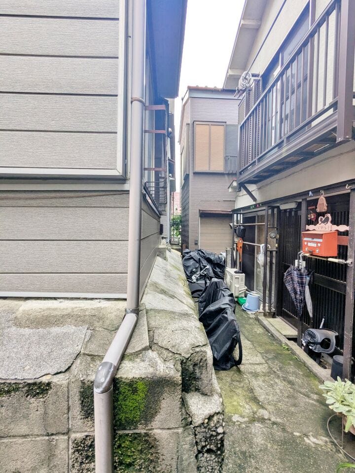 古家の側面と建物の間の通路を撮影。足元の段差や周囲との距離感も、現地で確認しておきたいポイントです。