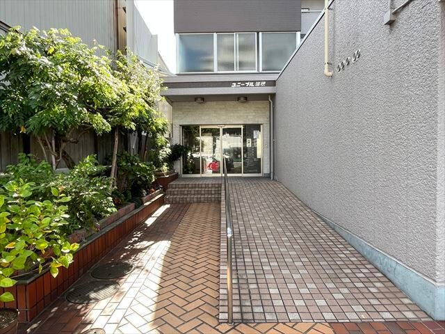 マンション北東側エントランスです。スロープが付いていますので、車椅子での通行も可能です。