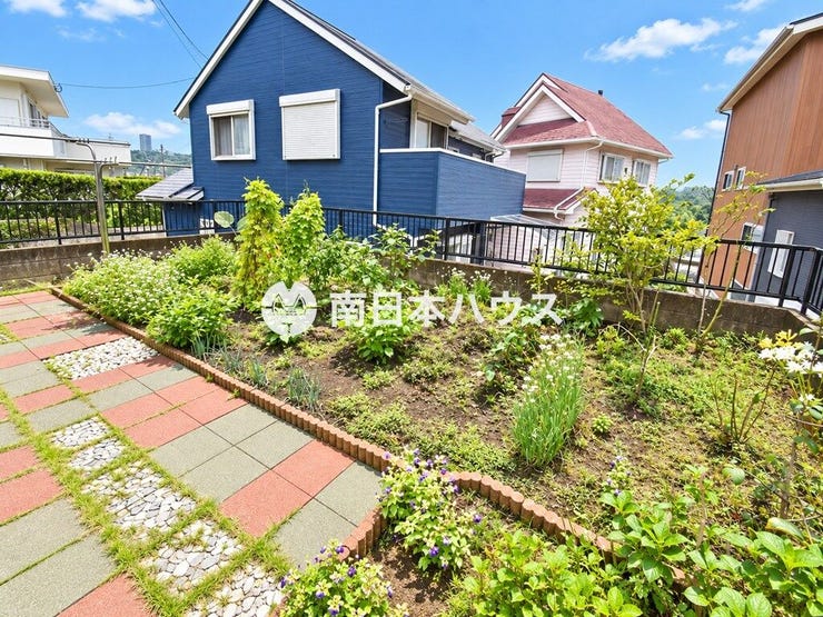 緑豊かなお庭。植栽スペースと園路があり、季節の草花を楽しめる空間です。