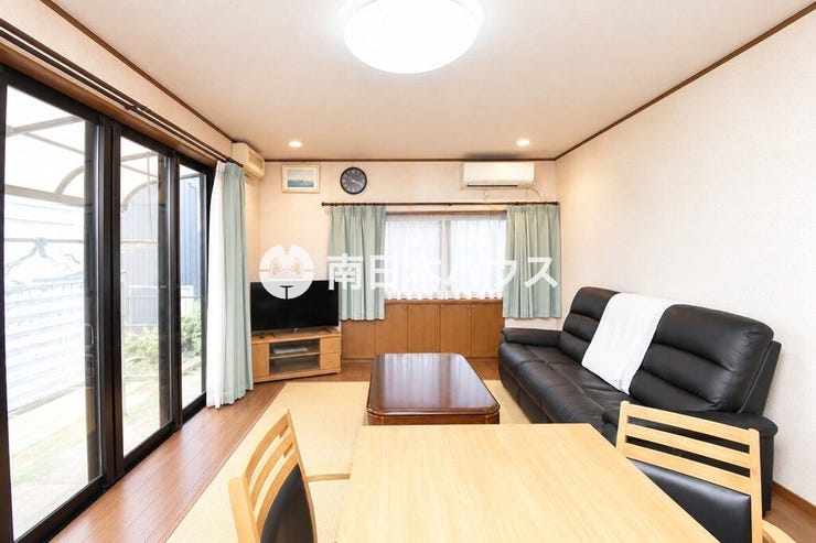 大きな窓から光が差し込む明るいLDK。タタミコーナーを備え、くつろぎやすい空間です。