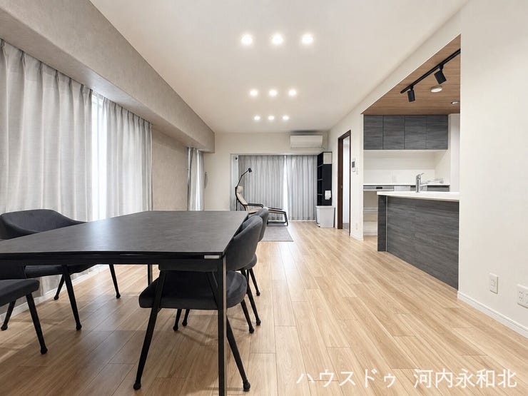 光とゆとりに満ちた開放的なLDK。グレーのアクセントクロスが洗練された空間を演出します。